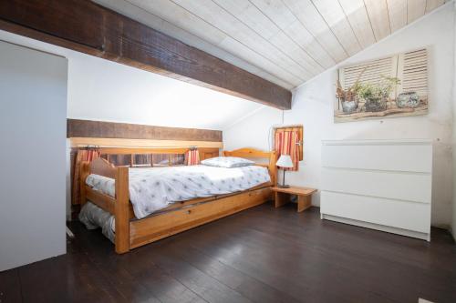 1 dormitorio con cama de madera en una habitación en El Sama-In , Piscine chauffée, en LʼIsle-sur-la-Sorgue