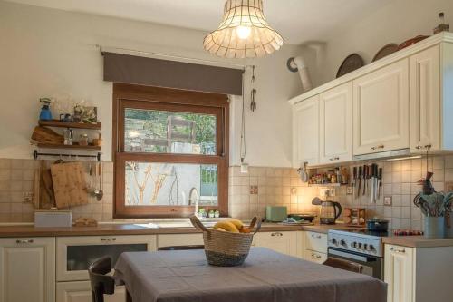 a kitchen with a table with a basket of fruit on it at Odysseas Pelion House in Kalamaki