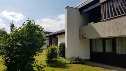 una casa con un árbol delante de ella en Exklusive Ferienwohnung Hattorfer Teiche en Wolfsburg