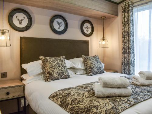 een slaapkamer met een groot bed met twee klokken aan de muur bij Dodd - Uk42499 in Bassenthwaite
