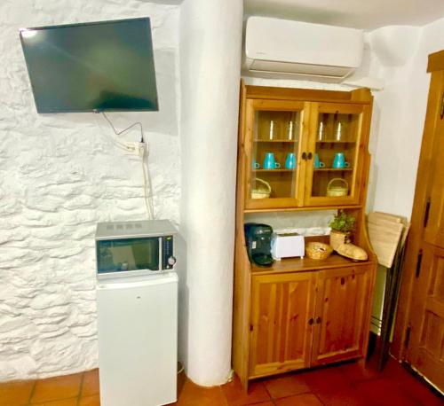 a room with a tv and a small refrigerator at Casa Soportújar las flores in Soportújar