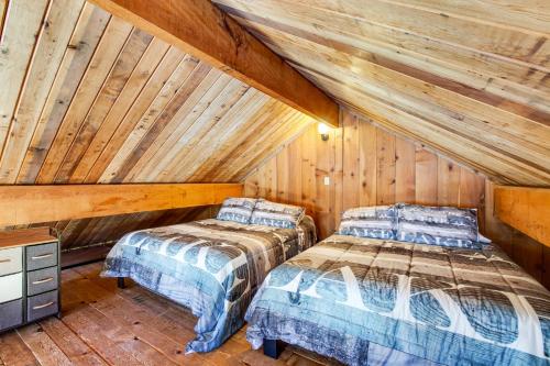 two beds in a room with wooden walls at Lake Sutherland in Port Angeles