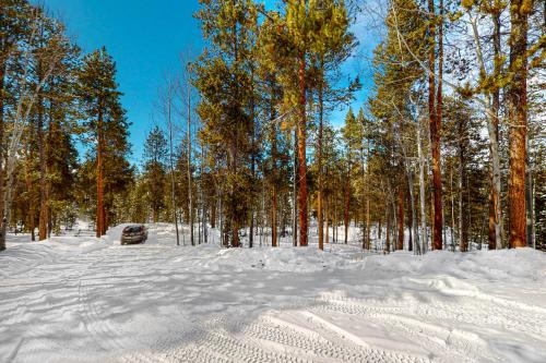 a car parked in the snow next to trees at Sunset Chalet in Tabernash