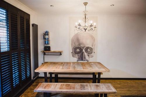 une chambre avec une table et un crâne sur le mur dans l'établissement •MangoHausLondon• •airconditioned•garden•fire pit•, à Londres