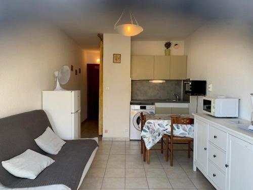 une cuisine et un salon avec un canapé et une table dans l'établissement Studio cosy à Balaruc-les-Bains - Animaux admis, proche Thermes - FR-1-503-98, à Balaruc-les-Bains