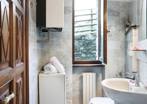 a bathroom with a sink and a toilet and a window at L'antica Lodge in Cremia