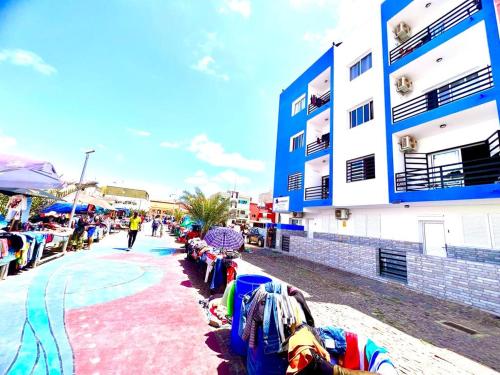 a group of people sitting on a sidewalk next to a building at Animoss! Apartments - 10 modern apartments near city center & beach in Santa Maria