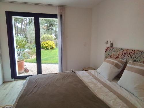 a bedroom with a large bed and a large window at Laie des Landes in Soucelles