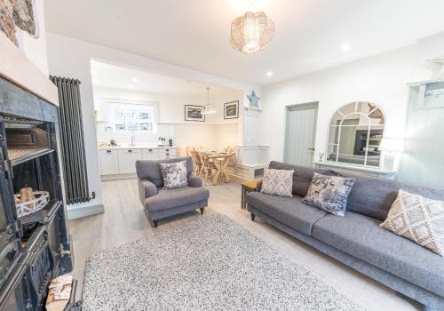 a living room with a couch and chairs and a kitchen at Brandelhowe in Keswick