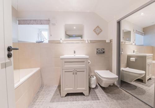 een badkamer met een wastafel, een toilet en een bad bij Brandelhowe in Keswick