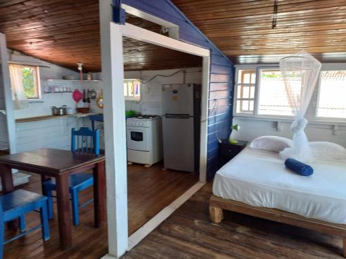 a bedroom with a bed and a table and a kitchen at Elba House in Bocas del Toro