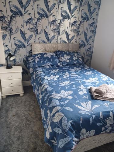 um quarto com um papel de parede floral azul e branco em Ripon Street Lincoln em Lincoln