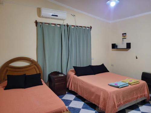 1 dormitorio con 2 camas y ventana en Lo De Mir en Salta