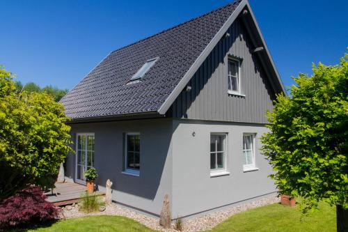 a white and black house with a black roof at Ferienhaus Buhne 31 in Prerow