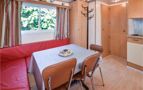 - une salle à manger avec une table et un canapé rouge dans l'établissement Pet Friendly Stacaravan, à Entraigues-sur-la-Sorgue