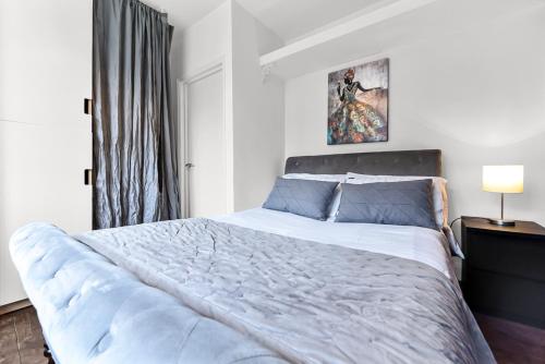 a bedroom with a large bed and a window at Leafy Oasis Wandsworth Chic Pad in London