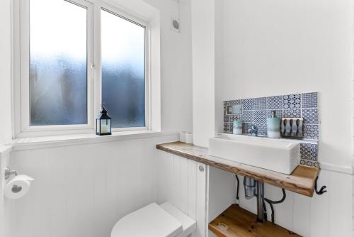 a bathroom with a sink and a window at Leafy Oasis Wandsworth Chic Pad in London