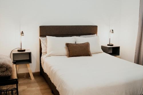 - une chambre avec un grand lit blanc et deux lampes dans l'établissement Casa Colibri @ Guadalupe Valley, à Valle de Guadalupe