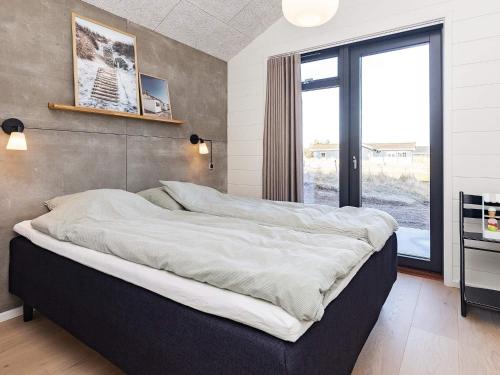 a large bed in a room with a large window at 8 person holiday home in Hirtshals-By Traum in Hirtshals