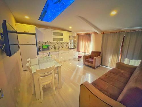 uma cozinha e sala de estar com uma mesa e um sofá em Helen Suit em Çaykara