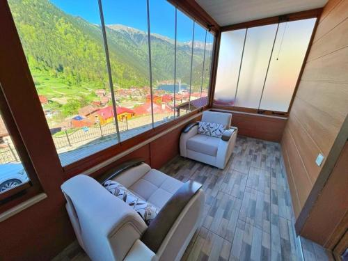 a room with two couches and a large window at Helen Suit in Çaykara