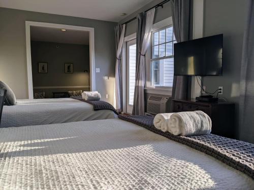 a bedroom with two beds and a flat screen tv at Stanton House Inn in Greenwich