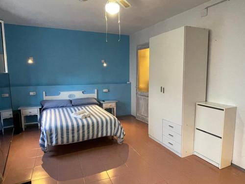 a bedroom with a bed and a blue wall at P&R hostals Can Tort in Tossa de Mar