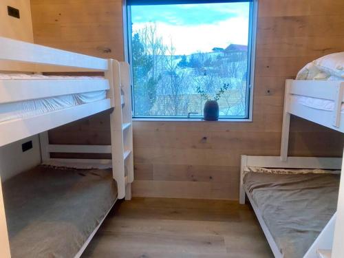 a room with two bunk beds and a window at The Oak house - Designers private Northern lights geothermal Villa in Mosfellsbær
