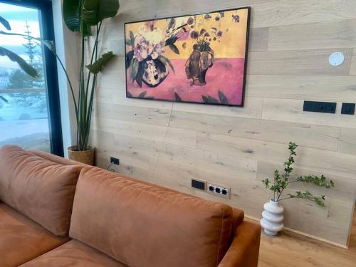 a living room with a couch and a painting on the wall at The Oak house - Designers private Northern lights geothermal Villa in Mosfellsbær
