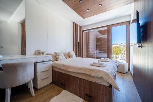 a bedroom with a bed with a sink and a window at BOROVI ROYAL wellness&spa in Divčibare