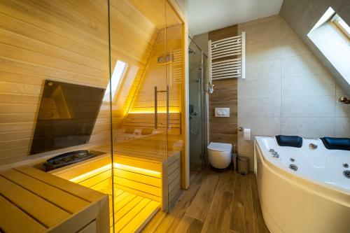 a bathroom with a shower and a tub and a sink at BOROVI ROYAL wellness&spa in Divčibare