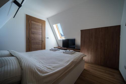 a bedroom with a large bed and a television at BOROVI ROYAL wellness&spa in Divčibare
