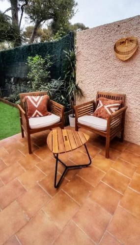 2 chaises en osier et une table sur la terrasse dans l'établissement Studio Le Kokonati, à La Ciotat