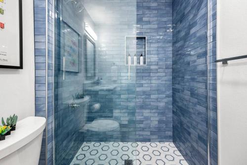 a bathroom with a shower with blue tiles at The 1 at Biarritz-Remodeled 1 br in Downtown PS in Palm Springs