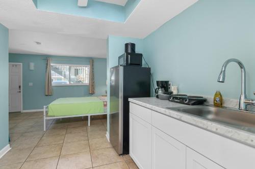 a kitchen with a refrigerator and a sink at Latitude 26 Waterfront Resort and Marina in Fort Myers Beach
