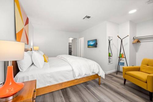 a bedroom with a bed and a yellow chair at The 1 at Biarritz-Remodeled 1 br in Downtown PS in Palm Springs