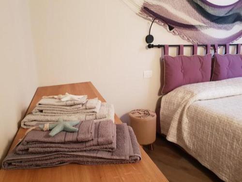 ein Schlafzimmer mit einem Tisch, Handtüchern und einem Bett in der Unterkunft La piccola casa di Ubs in Sestri Levante