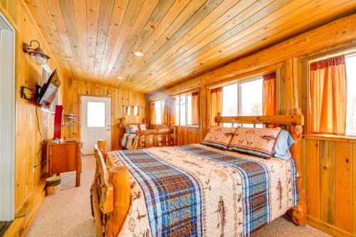 a bedroom with a bed in a wooden room at Cody Vacation Rental Near Cedar Mountain! in Cody