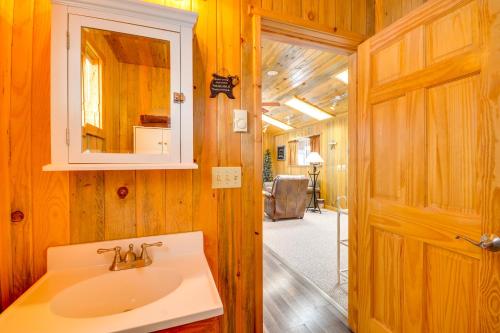 a bathroom with a sink and a mirror and a door at Cody Vacation Rental Near Cedar Mountain! in Cody