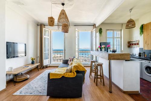 un salon avec un canapé et une cuisine dans l'établissement T2 vue mer au pied de La Major, à Marseille