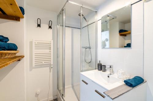 une salle de bain blanche avec une douche et un lavabo dans l'établissement T2 vue mer au pied de La Major, à Marseille