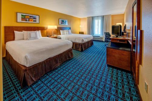 a hotel room with two beds and a television at Fairfield Inn and Suites by Marriott Orlando Near Universal Orlando in Orlando