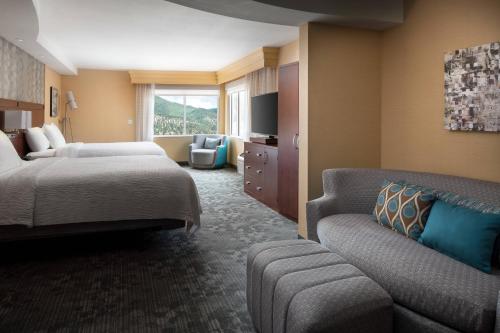 ein Hotelzimmer mit einem Bett und einem Sofa in der Unterkunft Courtyard by Marriott Glenwood Springs in Glenwood Springs