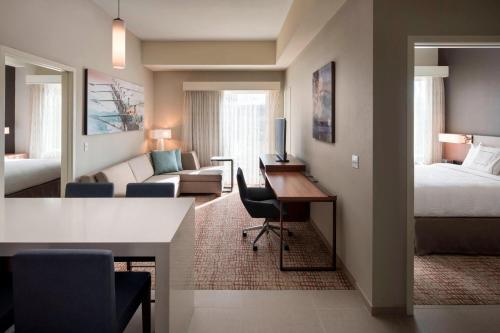 a living room with a bed and a desk in a room at Residence Inn by Marriott Detroit Sterling Heights in Waldenburg