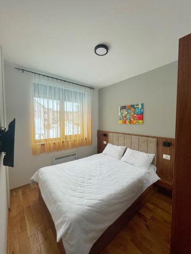 a bedroom with a white bed and a window at Apartman Bella, Titova Vila, Zlatibor in Zlatibor