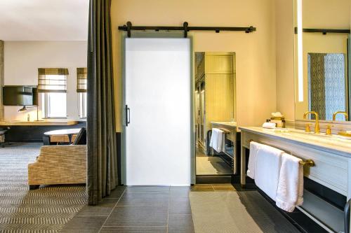 a bathroom with a sink and a large mirror at WATERMARK Baton Rouge, Autograph Collection in Baton Rouge