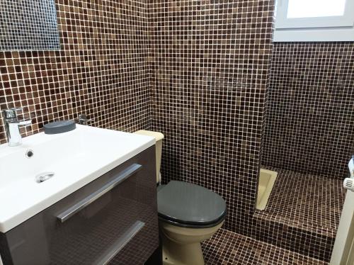 Łazienka z czarną toaletą i umywalką w obiekcie GARAT w mieście Saint-Jean-de-Luz