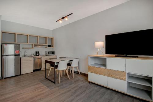 a kitchen and dining room with a table and a flat screen tv at TownePlace Suites by Marriott Cincinnati Airport South in Florence