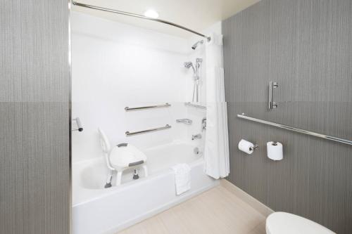 a bathroom with a tub and a toilet and a sink at Courtyard by Marriott Bowie in Bowie