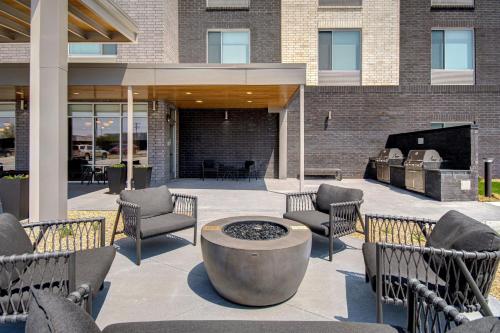 a patio with chairs and a fire pit in front of a building at TownePlace Suites by Marriott Cincinnati Airport South in Florence